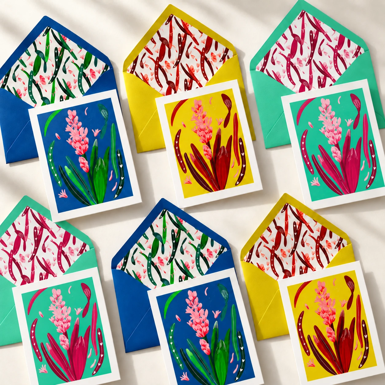 Six cartes Jacinthe et leurs enveloppes assorties, en bleu, jaune et vert sur fond crème