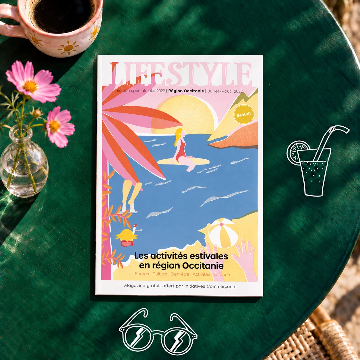 Magazine Lifestyle sur une table de café verte, avec une tasse rose, des cosmos et des pictogrammes blancs